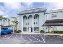 Beautiful exterior view of building with covered parking and well-maintained landscaping, blue truck on the left at 1706 Belleair Forest Dr # 336, Belleair, FL 33756