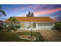 Charming single-story home with a well-maintained lawn, bright orange roof and attached two car garage at 1805 Granville Ln, Sun City Center, FL 33573