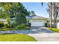 Charming single-story home featuring an attached two-car garage and mature landscaping at 18132 Oakdale Rd, Odessa, FL 33556