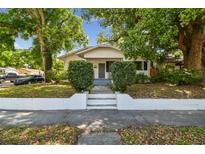 Charming bungalow-style home with lush trees, manicured shrubs, and a welcoming front entrance at 3411 N 12Th St, Tampa, FL 33605