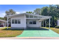 Charming single story home with a covered parking area, well-maintained lawn, and inviting curb appeal at 34150 Estates Ln, Wesley Chapel, FL 33543