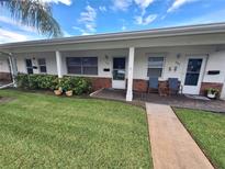 Charming condo featuring a cozy front yard, brick accents, and a welcoming covered entrance at 605 Brandy Wine Dr # 605, Largo, FL 33771