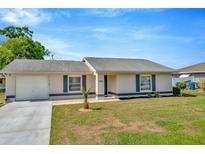 Charming single-story home featuring a well-maintained lawn, attached garage, and neutral color palette at 7041 Lexington Cir, Brooksville, FL 34602