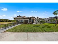 Beautiful single-story home featuring a well-manicured lawn, a two-car garage, and a tile roof at 8118 Thruso Rd, Port Charlotte, FL 33981