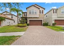Charming two-story home featuring a brick driveway, attached garage and well-manicured lawn at 935 Terra Vista St, Brandon, FL 33511