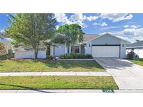 Charming single-story home featuring a well-manicured lawn and a two-car garage at 1472 Overland Dr, Spring Hill, FL 34608