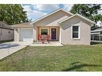 Charming single-story home with a well-maintained lawn, front porch, and a single-car garage at 1614 E Nome St, Tampa, FL 33604