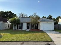 Charming single-story home with a well-manicured lawn and an attached garage at 2140 Redleaf Dr, Brandon, FL 33510