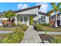 Charming single Gathering home with a well-manicured lawn, walkway, and a bright yellow front door at 511 45Th N Ave, St Petersburg, FL 33703