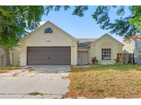 Charming single-story home featuring an attached garage, well-lit windows, and landscaped front yard at 8421 Unity Dr, Port Richey, FL 34668