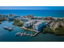 Stunning aerial view of a beachfront condo complex with boat docks and ocean views in a tropical setting at 19531 Gulf Blvd # 205, Indian Shores, FL 33785