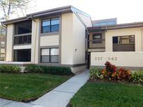 Inviting exterior showcasing a well-maintained lawn and charming two-story condo units in a tranquil community at 337 Woodlake Wynde, Oldsmar, FL 34677