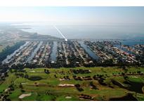 Stunning aerial view of waterfront homes, boat docks, and a golf course in a vibrant coastal community at 3901 E Eden Roc Cir, Tampa, FL 33634