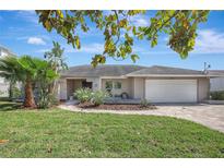 Charming single-story home with lush landscaping, paved driveway, and an attached two car garage at 3901 E Eden Roc Cir, Tampa, FL 33634