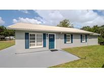 Charming single-story home featuring gray paint, blue shutters, and a light-colored metal roof at 4508 26Th S Ave, Tampa, FL 33619