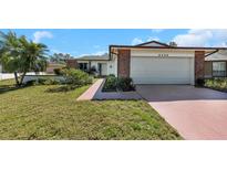 Charming single-story home with a well-maintained front lawn and colorful landscaping at 4534 Great Lakes S Dr, Clearwater, FL 33762