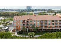Multi-story condominium featuring a terracotta-tile roof, balconies, and picturesque waterfront views at 5000 Culbreath Key Way # 9-104, Tampa, FL 33611