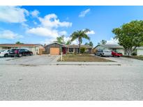 Charming single-story home featuring a well-kept front yard with mature landscaping and a spacious driveway at 6821 Tierra Verde St, Port Richey, FL 34668