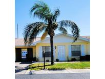 Charming single-story home with yellow siding, white trim, and well-manicured lawn, inviting curb appeal at 1012 Warwick Ct, Sun City Center, FL 33573