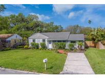 Charming single-story home with a well-maintained lawn, mature landscaping, and a concrete driveway at 1536 Alamo Ln, Dunedin, FL 34698