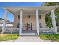 Charming two-story home featuring an inviting front porch with stately columns and a red door at 1842 Nebraska Ne Ave, St Petersburg, FL 33703