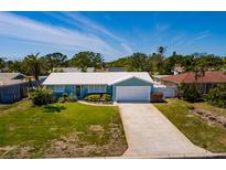 Charming single-story home with a well-maintained lawn and a long driveway leading to the garage at 2972 E Vina Del Mar Blvd, St Pete Beach, FL 33706