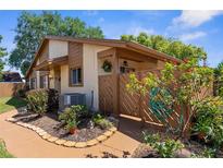 Charming home featuring neutral stucco siding, wood accents, and landscaped front yard with a cozy, fenced-in entrance at 4022 Lighthouse Way, New Port Richey, FL 34652