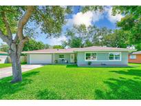 Charming single-story home featuring a well-manicured lawn and mature shade tree at 533 Keene Rd, Largo, FL 33771