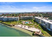 Stunning aerial view of beachfront condos with pool, beach, and lush landscaping on a sunny day at 6021 Bahia Del Mar Cir # 534, St Petersburg, FL 33715