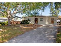 Charming single-story home with a well-manicured lawn, a mature shade tree, and a spacious driveway at 721 75Th N Ave, St Petersburg, FL 33702