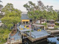 Expansive backyard deck overlooking the water with a boat lift, gazebo, and seating at 7500 N Ola Ave, Tampa, FL 33604
