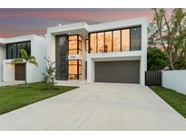 Modern two-story home boasting large windows, a grey two-car garage, and minimalist landscaping at 7608 Antilla St, Tampa, FL 33625
