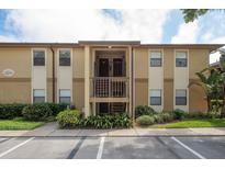 A two-story condo building with parking in front and green landscaping at 12293 Sailwinds Dr # 206, Largo, FL 33773