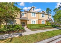 Beautiful townhome with tan and beige colors, lush landscaping, and a well-maintained walkway to the front door at 14726 Brick Pl, Tampa, FL 33626