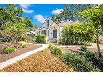 Charming two-story home with a beautifully landscaped front yard with green foliage and a stone pathway at 150 23Rd N Ave, St Petersburg, FL 33704