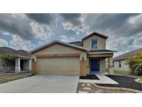 Charming two-story home with a two-car garage and neutral-toned facade at 15411 Quail Woods Pl, Ruskin, FL 33573