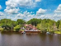 Waterfront home with private dock, serene lake views, and lush landscaping creating a peaceful oasis at 17301 Estes Rd, Lutz, FL 33548
