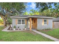 Charming single-story home with a well-maintained lawn and decorative shutters at 2001 E Idlewild Ave, Tampa, FL 33610