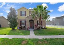 Charming two-story home with a well-manicured lawn, a stone-accented entry, and lush landscaping at 21046 Passive Porch Dr, Land O Lakes, FL 34637