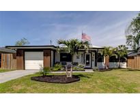 Charming single-story home featuring a well-manicured lawn, modern design, and an attached one car garage at 2488 Del Rio Way, Dunedin, FL 34698
