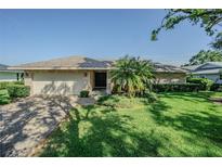 Charming single-story home featuring a well-manicured lawn and brick driveway at 601 Riviera Bay Ne Dr, St Petersburg, FL 33702