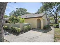 Charming exterior view of home featuring an arched entry and landscaped walkway to the front door at 6262 142Nd N Ave # 1106, Clearwater, FL 33760