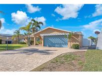 Charming home featuring a spacious blue garage door, neutral paint color, and a patterned brick drive at 1012 Spindle Palm Way, Apollo Beach, FL 33572
