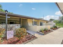 Inviting home exterior with a landscaped walkway leading to the entrance and a clear sky backdrop at 1203 16Th Se Cir, Largo, FL 33771