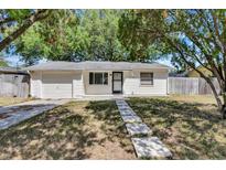 Charming home with a well-manicured front yard, stepping stone walkway, and a convenient attached garage at 129 Nw Lincoln N Cir, St Petersburg, FL 33702
