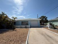 A charming home with a one-car garage, blue exterior, and minimalist rock landscaping at 195 45Th Ave, St Pete Beach, FL 33706