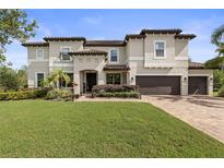 Two-story home boasts a three-car garage, well-manicured lawn, and a charming neutral-tone exterior at 19810 Prince Benjamin Dr, Lutz, FL 33549