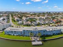 An aerial view displays a waterfront condo, nestled among landscaped residences and waterways at 280 126Th Ave # 106, Treasure Island, FL 33706
