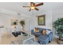 Cozy living room featuring a modern sofa, glass coffee table, and adjacent dining area with natural light at 455 Alt 19 # 111, Palm Harbor, FL 34683