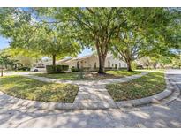 Well-maintained home exterior with mature trees and landscaping, providing shade and curb appeal at 5482 Salem Square N Dr, Palm Harbor, FL 34685